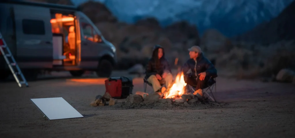 Pareja de viajeros en una van acampando y disfrutando del anochecer con una antena de starlink Mini 
